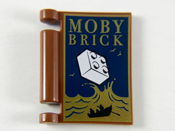 Part 24093pb026 - Minifigure, Utensil Book Cover with Gold Ocean and 'MOBY BRICK', White Brick, Black Rowboat Pattern - De BrickPlaats