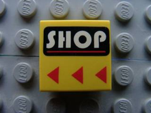 Part 3068px29 - Tile 2 x 2 with White 'SHOP' and Red Line on Black Rounded Rectangle, Red Triangles Pattern - De BrickPlaats